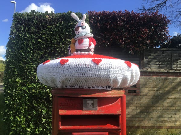 Crocheted Easter bunny atop a traditional red British post box