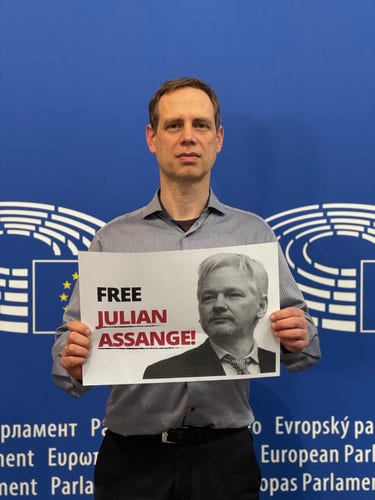 Photo of Pirate MEP Patrick Breyer holding a sign "Free Julian Assange"