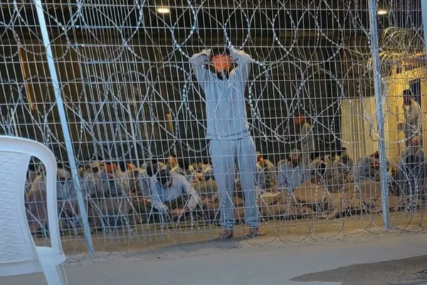 A leaked photograph of the detention facility shows a blindfolded man with his arms above his head: