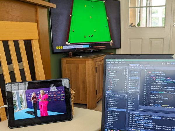 Point of view from my seat on the living room couch. From left to right: an iPad with the YouTube livestream of the Eurovision opening ceremony interviews, our TV showing the final of the snooker world championship, and my laptop screen featuring my current Godot game project.