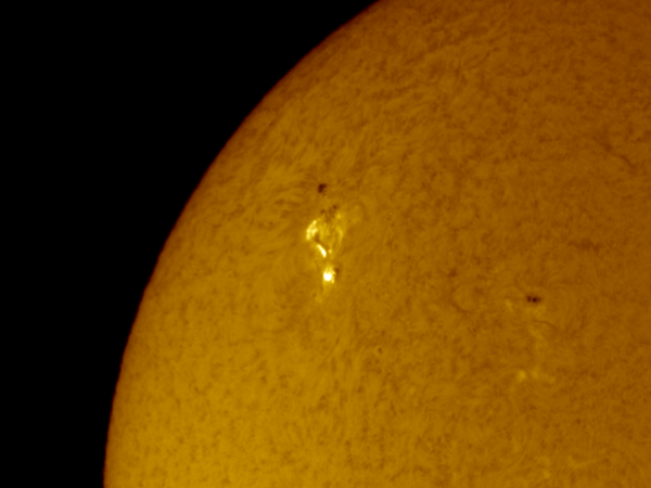 A quadrant of the sun's surface with a few especially bright spots visible