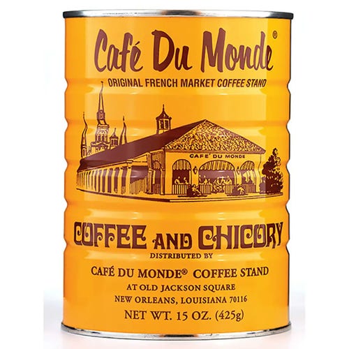 A gold can of Cafe Du Monde Coffee and Chicory blend, label printed in brown text, on a white background.