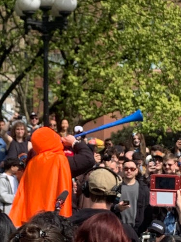 in a crowd, someone films the event through a nintendo 3DS
