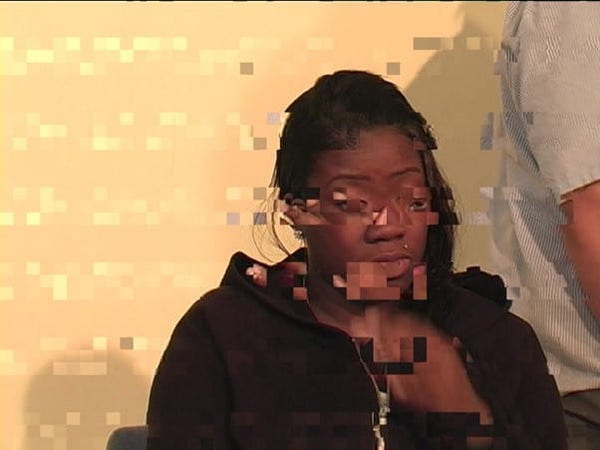 Screen capture of a woman talking, blocky with digital playback errors
