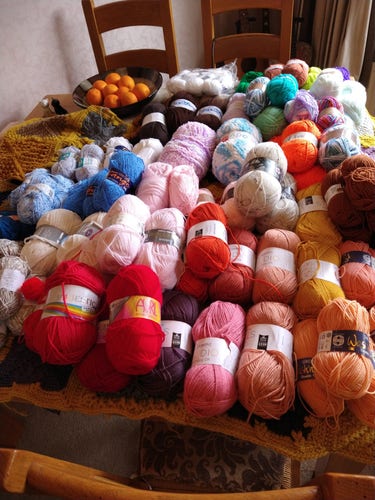 Dining table covered in various colours of yarn 