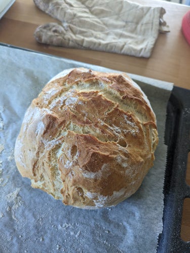 Photo d'un pain qui sort du four, un peu doré. 