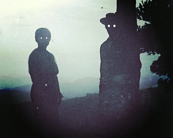 A depiction of the Dark Watchers, showing the silhouettes of a man and a woman; their eyes glow, but otherwise they are completely blacked out, the foggy sky behind them.