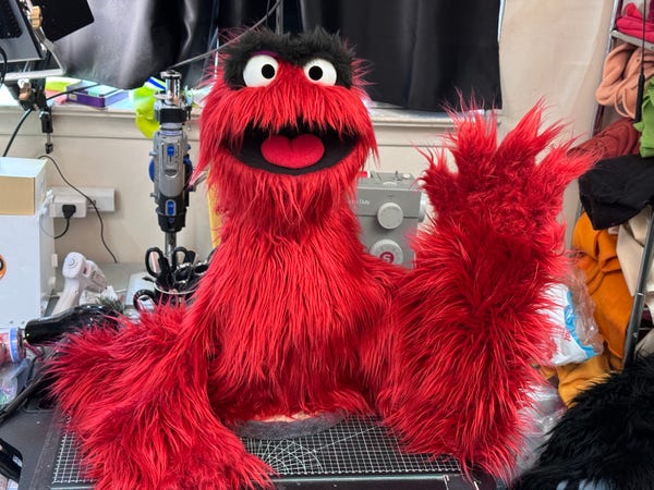 A red furry live hands monster sack puppet