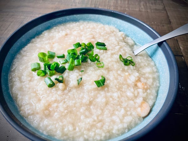 Bowl of rice porridge with green onion on top. 
