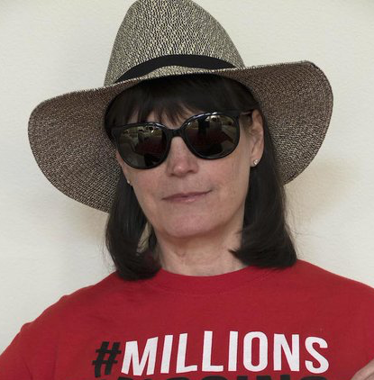Me, a white woman with collar length brown hair, wearing a red Millions Missing t-shirt. I'm also wearing a hat and sunglasses.