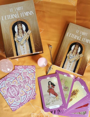 Le coffret du tarot de l'éternel féminin ouvert avec une photo du livret et de quelques cartes du jeu 