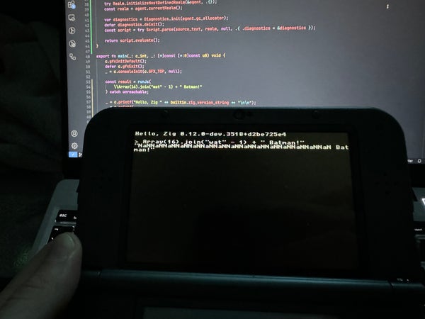 A Nintendo 3DS showing console-like output on the top screen. It printed the Zig version (latest 0.12-dev) and the famous demo from the "Wat" talk where joining an array of "string minus number" results in "NaNNaNNaNNaN[...] Batman".
In the background there's my laptop with the Zig code for this demo.