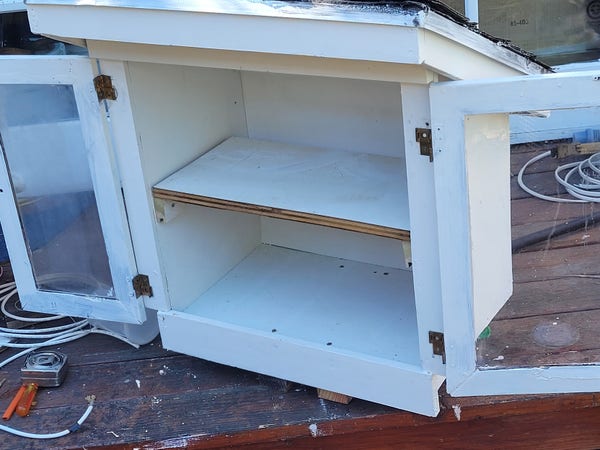 White box with shelf, and clear doors. 
