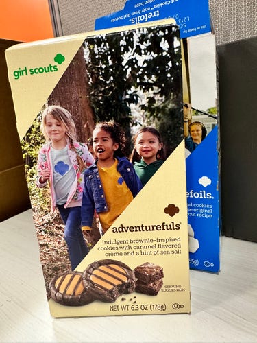Photo of a Girl Scout cookie box with the name "Adventurefuls". It's a brownie inspired cookie with caramel flavored crème and a hint of sea salt.