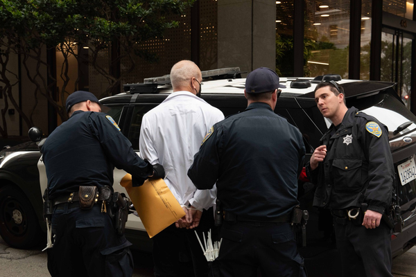 Image of #ScientistRebellion member Greg Spooner being arrested at a vigil action inside Wells Fargo headquarters decrying the harm their fossil fuel funding is causing.  