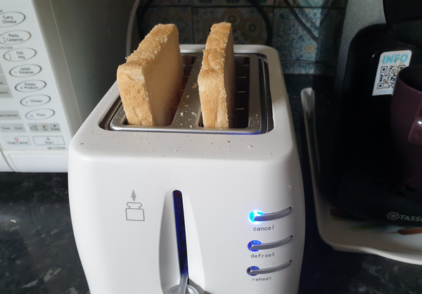 A toaster, with at least 25% of normal sized bread sticking out of it coquettishly 