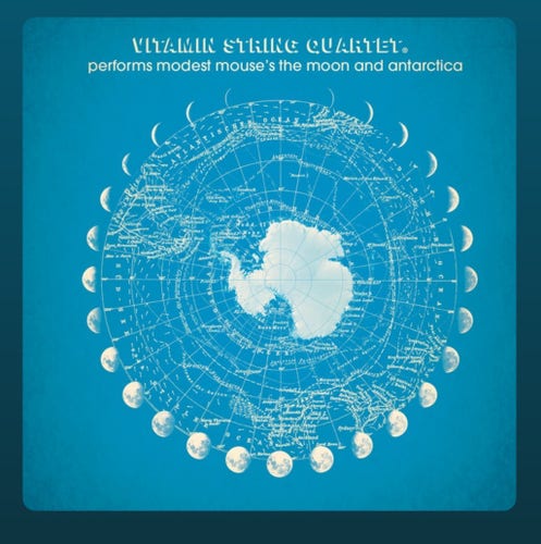 Album cover by vitamin string quartet covering modest mouse the moon and Antarctica. The cover is sky blue and features Antarctica superimposed over a white polar coordinate star chart and ringed by phases of the moon