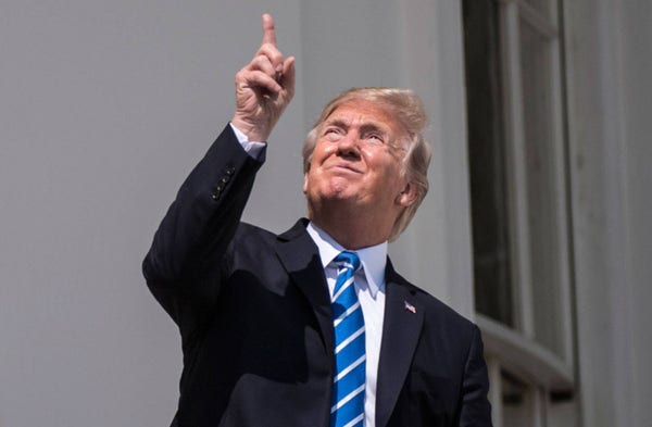 A photo of the time Donald Trump pointed and looked up at the sun during a press meeting when he was President.