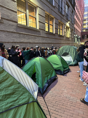 EMERSON: A line of tents in an alleyway, and people lined up on either side