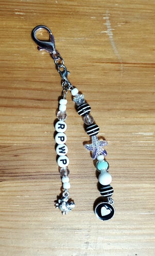 keychain in 2 strands with the letters RPWP, heart charm, crab charm, various beads in black, white, clear, and green