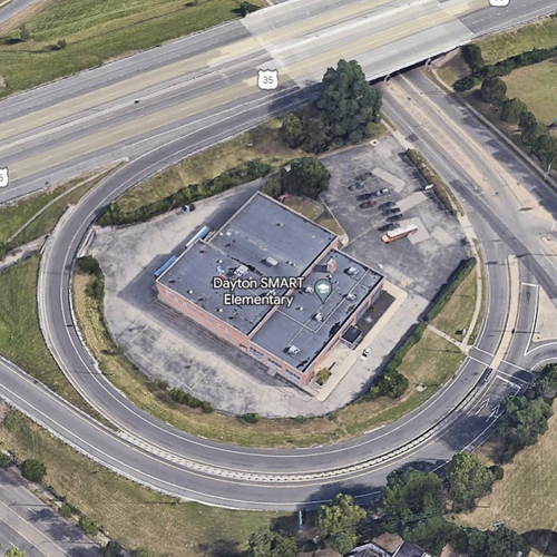 Google satellite photo of a school labeled "Dayton SMART Elementary" located inside one loop of a cloverleaf intersection of US Route 35.