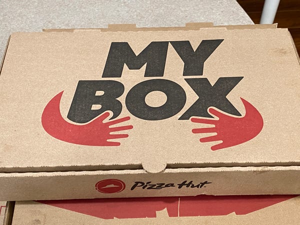 A cardboard box that says "My Box", with two hands reaching around as if to grab it.