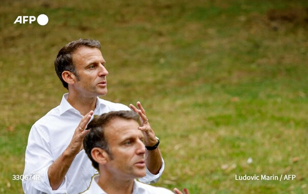 Emmanuel Macron holding the head of a much larger Emmanuel Macron