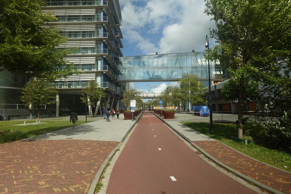 Photo of the Leiden University Medical Centre showing a bicycle path and a glass pedestrian bridge