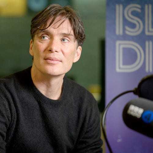 Head-and-shoulders shot of actor Cillian Murphy in a dark grey round-neck jumper. He's looking up and out of shot to his right. He's in a BBC radio studio - behind him a Desert Island Discs banner