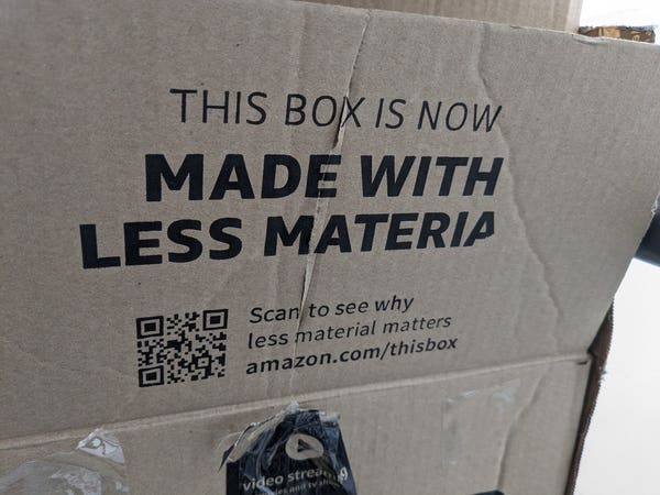 Amazon box that says "Made with less material," but the l is missing