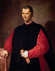 Portrait of Niccolò Machiavelli by Santi di Tito, c. 1550–1600.

Portrait of Niccolò Machiavelli standing in traditional Renaissance attire, featuring a black robe with a red mantle, posing with his right hand resting on a stone ledge, against a muted brown background.