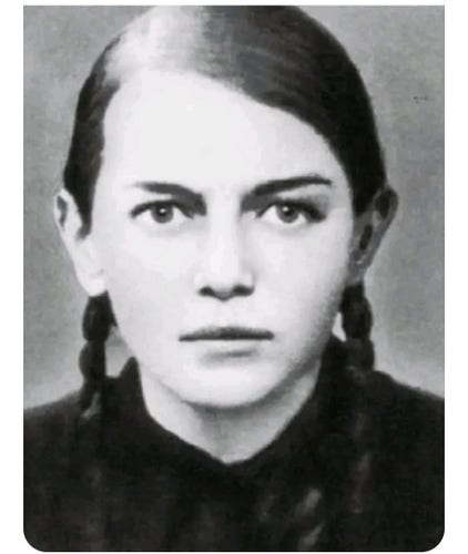 Black-and-white photo of her, young woman with braids, and a very intense expression on her face. 