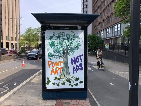 Un panneau de pub détourné avec une affiche artisanale.

Un dessin d'arbre et un slogan "Plant art, not ads".