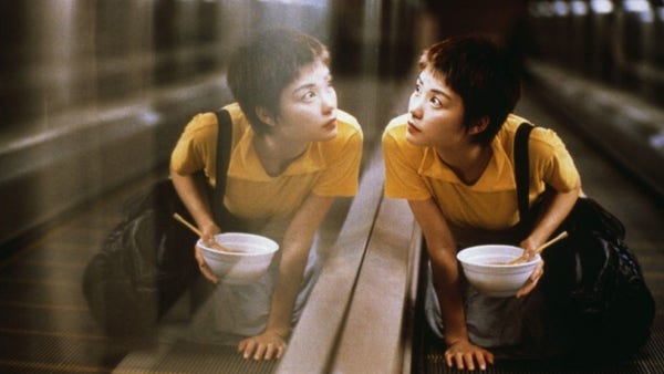Une image de Chinking Express. Le personnage féminin se regarde dans le miroir du mur latéral,d’un trottoir roulant dans le métro. 