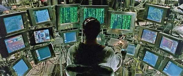 Operator Tank from the Matrix movies, sitting in front of many screens filled with information.