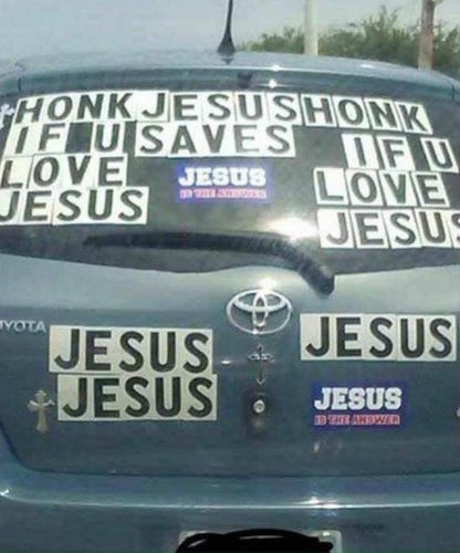 back of toyota hatchback with decals on them that say: honk jesus honk if u saves if u love love jesus jesus jesus jesus jesus (probably means to say Honk if you love jesus on the left and right and jesus saves in the middle) with a number of jesus stickers left over