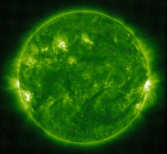Die erdzugewandte Seite der Sonne in grüner Darstellung, worauf der scherzhafte Vergleich mit dem Getränk anspielt. Aktive Regionen sind vor allem am linken und rechten Rand in hellen, fast weißen Farbtönen wiedergegeben.