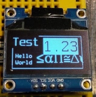 A tiny OLED display with several fonts on it showing transparancies, colors and alignments