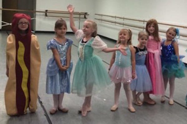 Dance class with several princesses and one confident, happy hot dog
