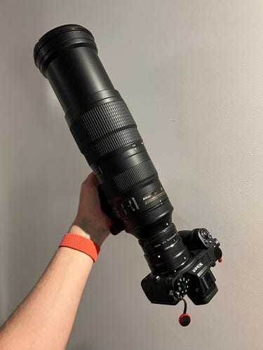 A Nikon Z 6 camera attached to an F to Z adapter, attached to a teleconverter, attached to a 200-500 mm zoom lens rotated to maximum zoom, making the whole camera setup very long and unwieldily