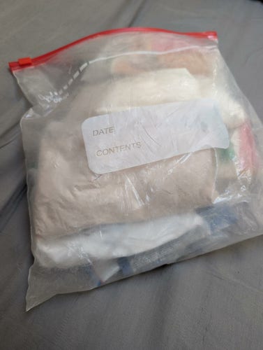 A freezer bag full of bags of powder in various colors, looking like what I — a total square — imagine a big bag of drugs would look like.