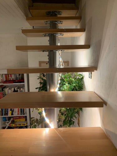 Planches d'escaliers en bois posées sur une structure en métal, pas de garde fou