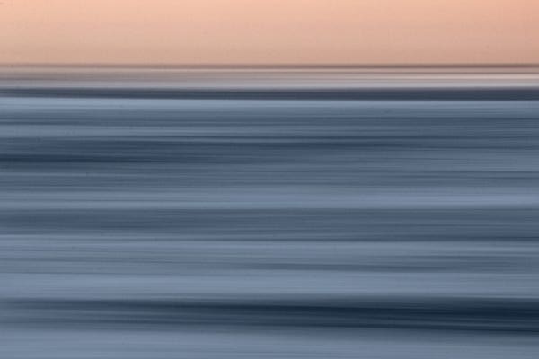 A blurred long exposure panning shot of the sea by early morning. The camera movement creates interesting texture.