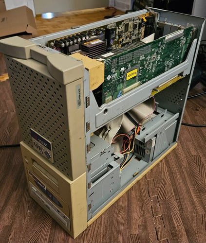 A sun Ultra 10 stood on its top, single U shaped panel set removed. A board is visible with a PCI breakout board as well as a daughter card. It is nowhere as dusty as you'd imagine.