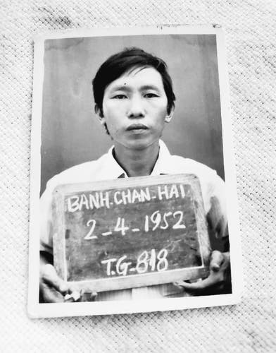 My Dad's mug shot at refugee camp. He is holding a chalkboard with his name & birthdate on it. 

Photo is black and white.
