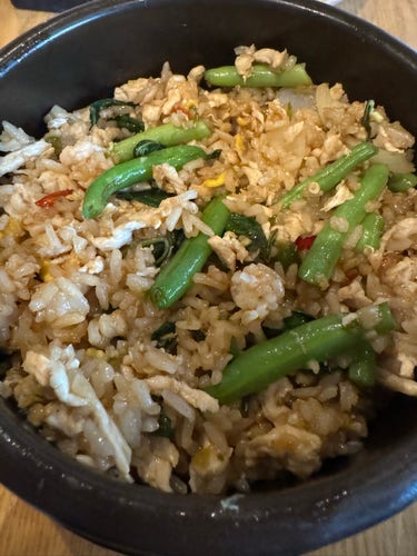 A bowl of fried rice with green beans and egg.
