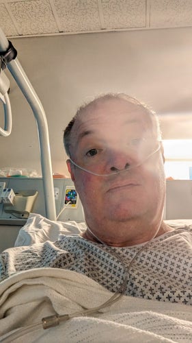 Me in my hospital bed, looking peeved at fate's terrible sense of timing.