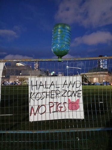 A water cooler bottle with a sign that says “Halal and Kosher Zone, no pigs 🐷 “ 