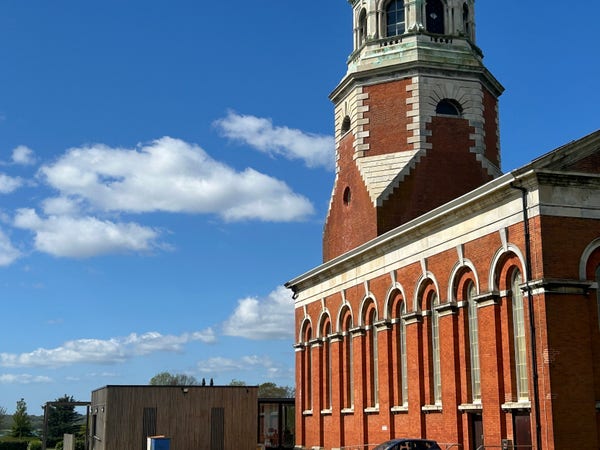 A red brick bell tower and chapel that used to be part of a large hospital in the Crimean war. Blue sky behind. 