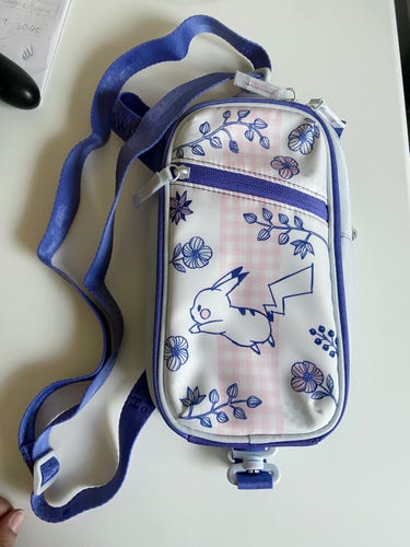 A rectangular bag with illustrations of pikachu and some flowers. The color schemes are white, pink and blue